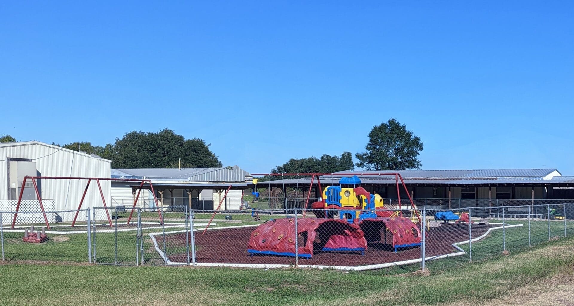 A playground with a red tarp and blue slide.