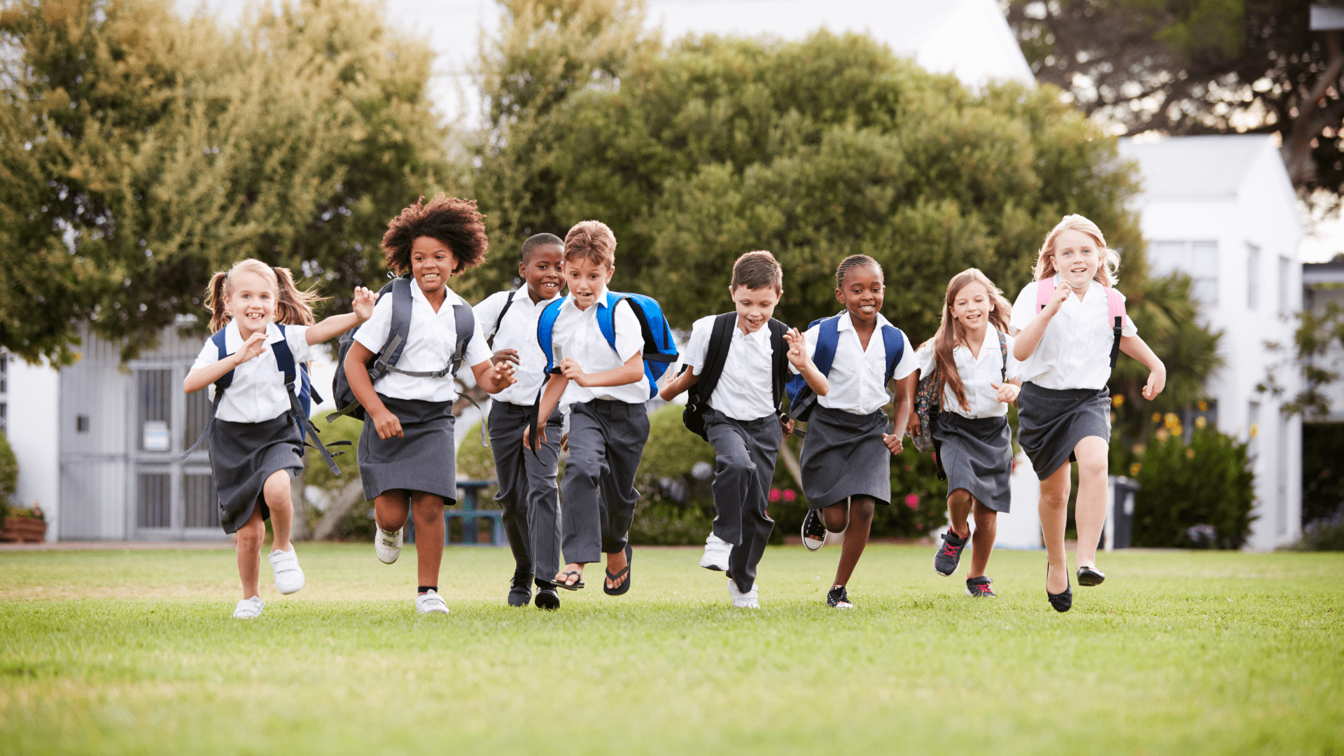 a group of children running on a grassy field