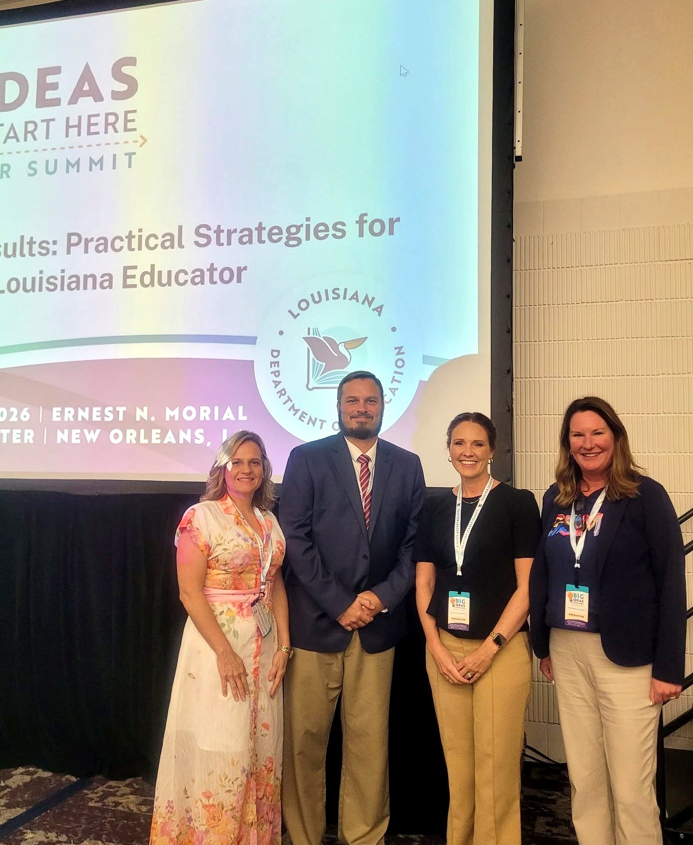 Grant Parish Public Schools team members gather in front of a Big Ideas Start Here Teacher Leader Summit presentation screen.